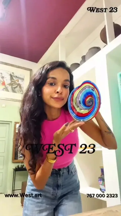 Aachal Jain holding a colourful art glass bowl during her visit to West23